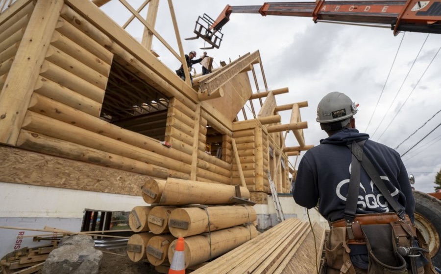 Crane lifting materials at a log home construction site in BC